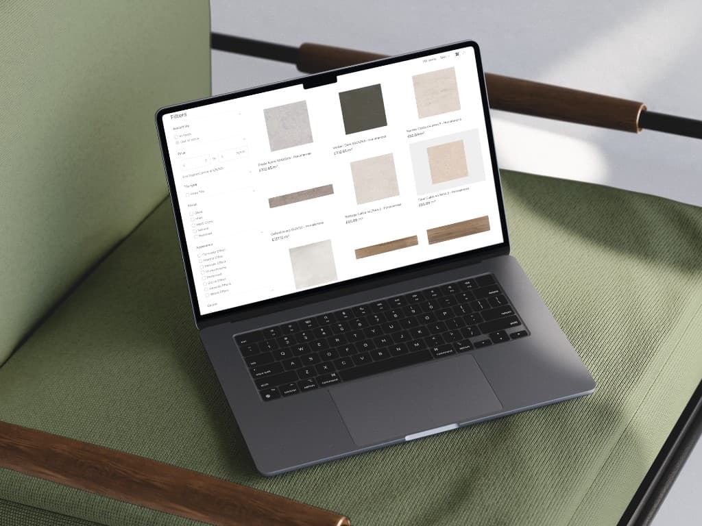 A laptop on a green chair showing the Forazzi tile collection, with filters for availability, price and finish